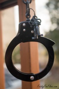 closeup of a closed handcuff. Keys are attatched to the chain between the two cuffs