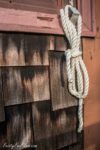 coiled white rope hangs from a window ledge